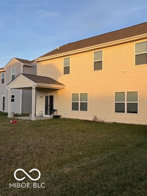 rear view of house with a lawn and a patio