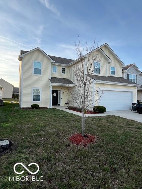 front of property featuring a garage, central air condition unit, and a front lawn