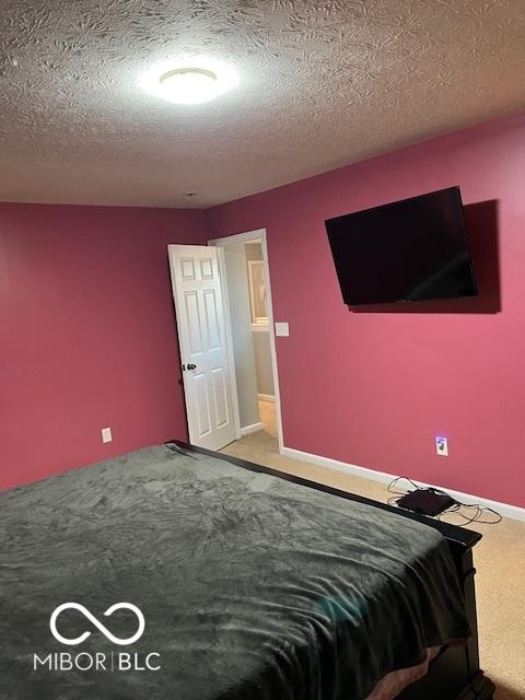 unfurnished bedroom featuring a textured ceiling and carpet