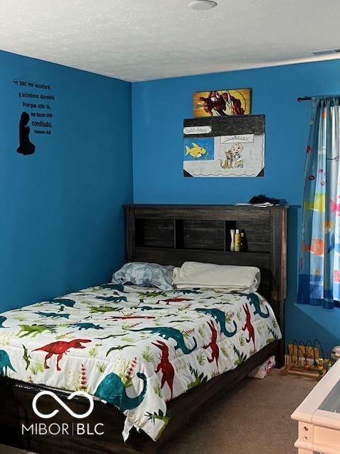 bedroom featuring a textured ceiling and carpet