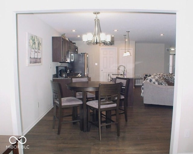 dining space with an inviting chandelier, dark hardwood / wood-style floors, and sink