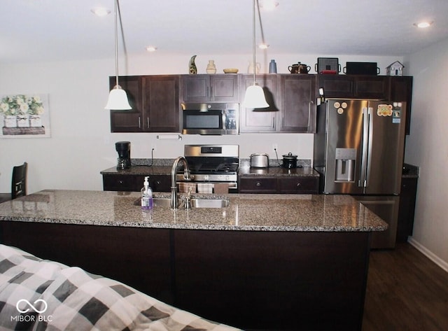 kitchen featuring light stone countertops, appliances with stainless steel finishes, and pendant lighting