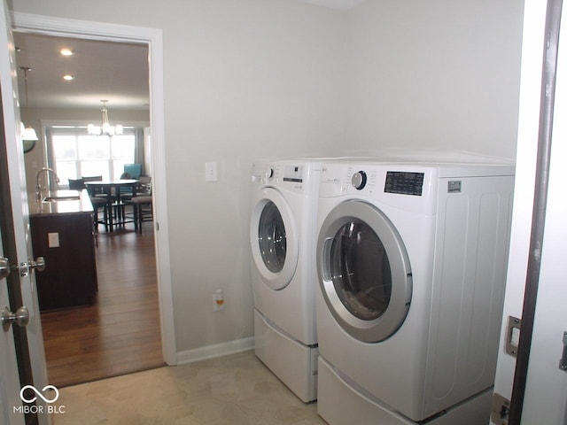 laundry area featuring sink, a chandelier, and independent washer and dryer