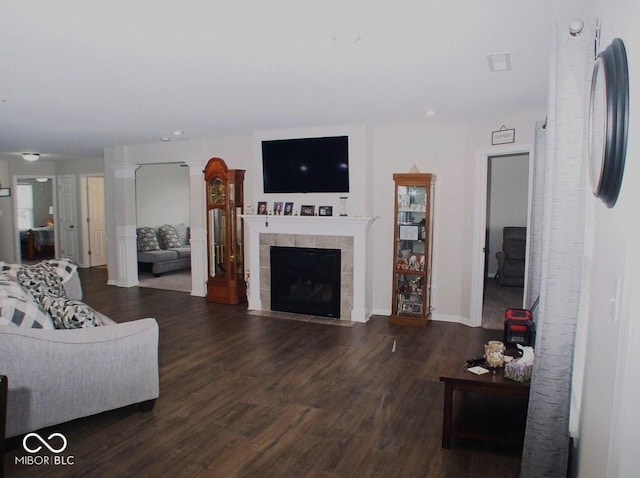 living room featuring dark wood-type flooring and a fireplace