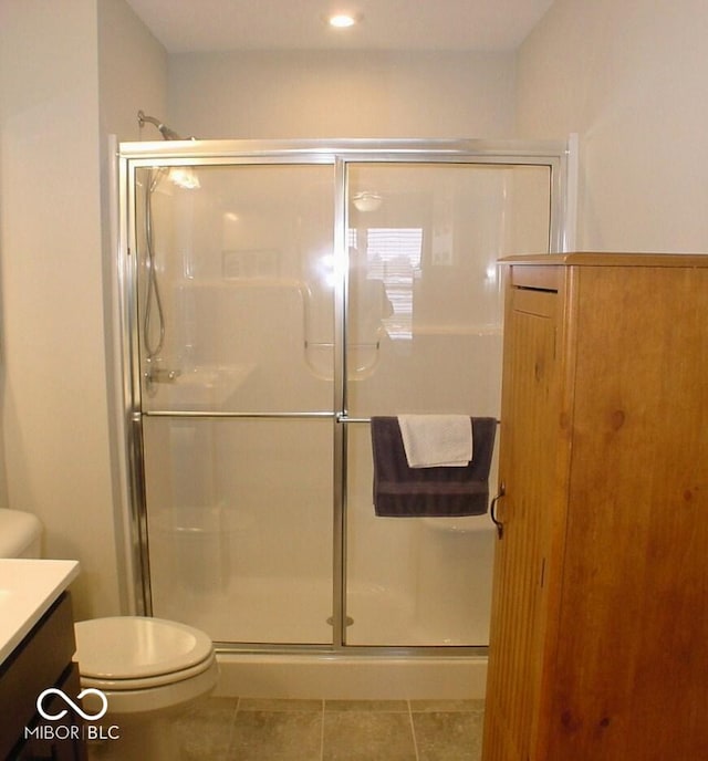 bathroom with vanity, an enclosed shower, tile patterned floors, and toilet