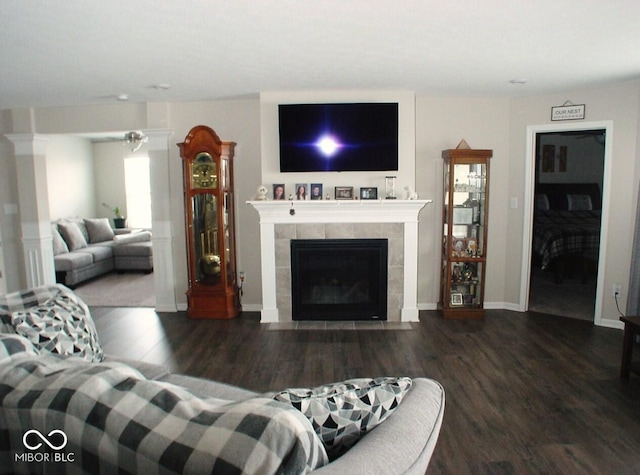 living room with dark hardwood / wood-style floors and a tile fireplace