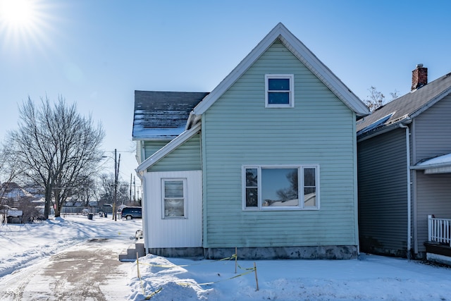 view of snow covered rear of property