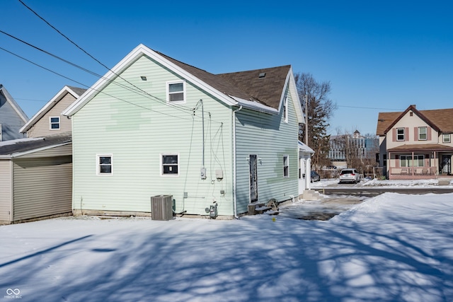 snow covered property with central AC unit