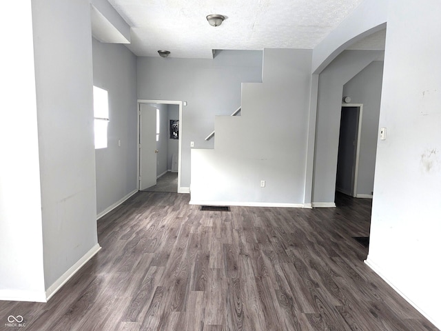 unfurnished room with a textured ceiling and dark hardwood / wood-style floors