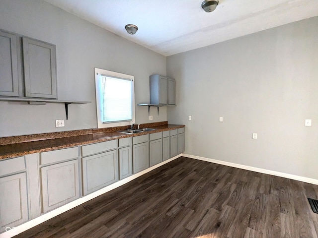 kitchen featuring dark wood-type flooring, gray cabinets, and sink