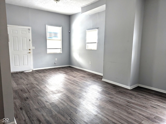 empty room featuring dark hardwood / wood-style floors and a textured ceiling