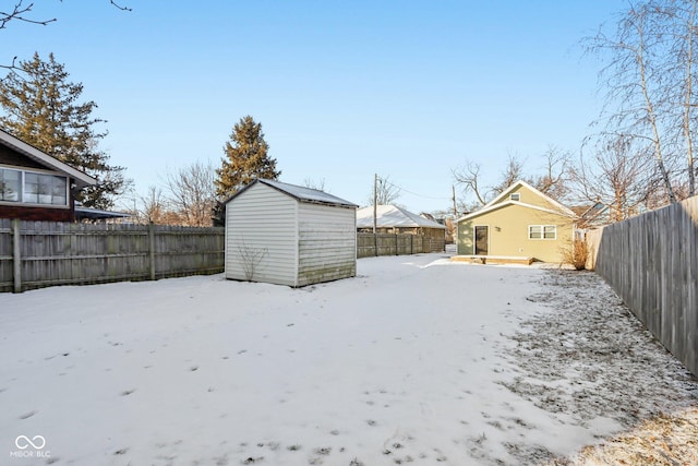 yard covered in snow featuring a storage shed