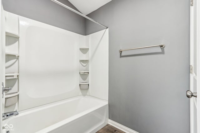 bathroom featuring hardwood / wood-style flooring and  shower combination