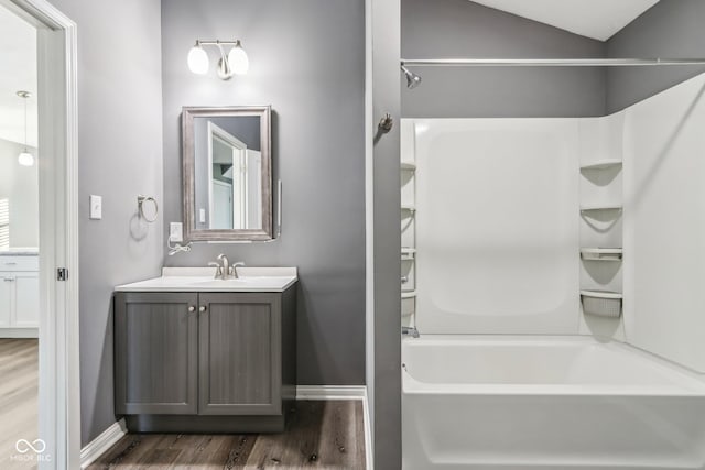 bathroom featuring shower / bath combination, vanity, vaulted ceiling, and hardwood / wood-style flooring