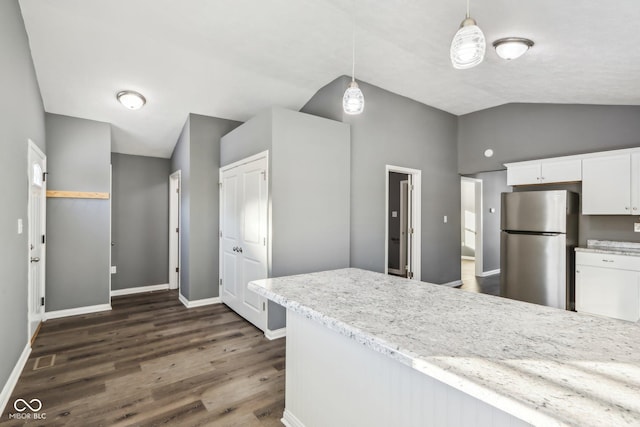 kitchen featuring lofted ceiling, stainless steel fridge, white cabinetry, hanging light fixtures, and dark hardwood / wood-style flooring