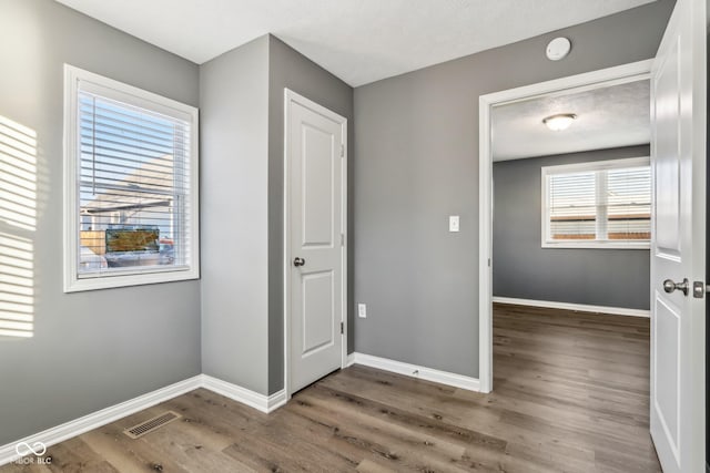 unfurnished bedroom with dark hardwood / wood-style floors