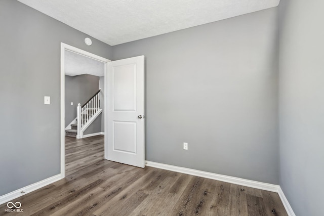 unfurnished room with dark hardwood / wood-style flooring