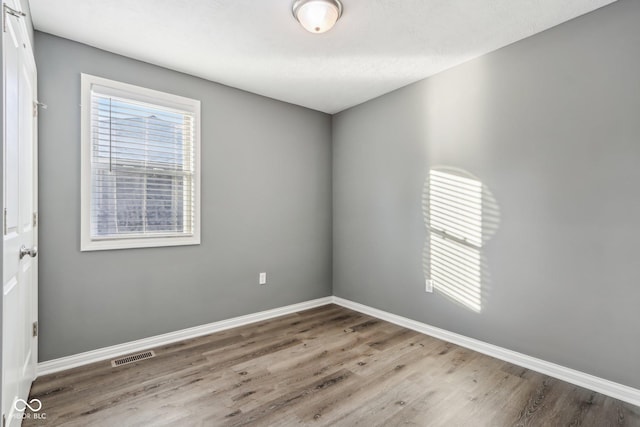 spare room with wood-type flooring