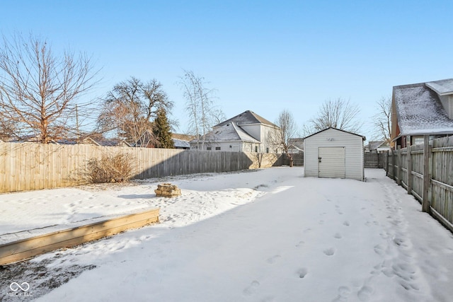 snowy yard featuring a storage shed