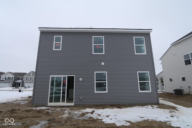 snow covered property with central AC