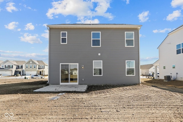 back of property with central air condition unit and a patio