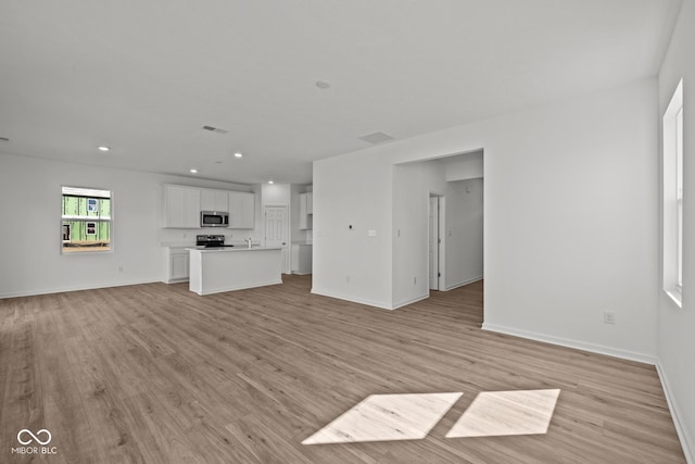 unfurnished living room featuring recessed lighting, visible vents, baseboards, and light wood finished floors