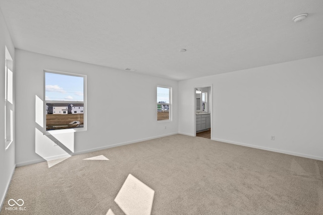 carpeted spare room with visible vents and baseboards