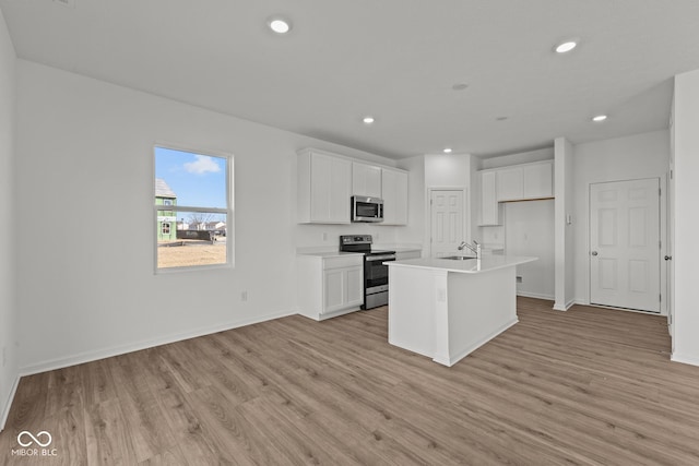 kitchen with recessed lighting, light wood-style flooring, appliances with stainless steel finishes, and white cabinets