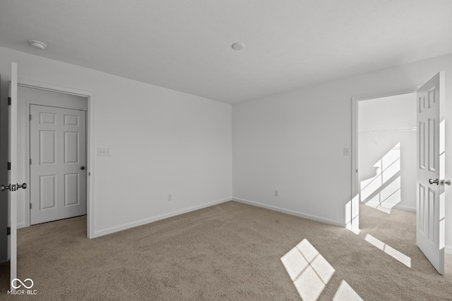 unfurnished room with baseboards and carpet flooring