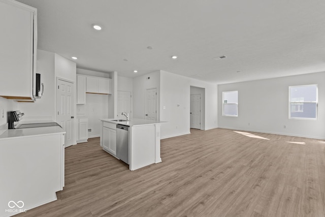 kitchen featuring white cabinetry, an island with sink, stove, dishwasher, and open floor plan