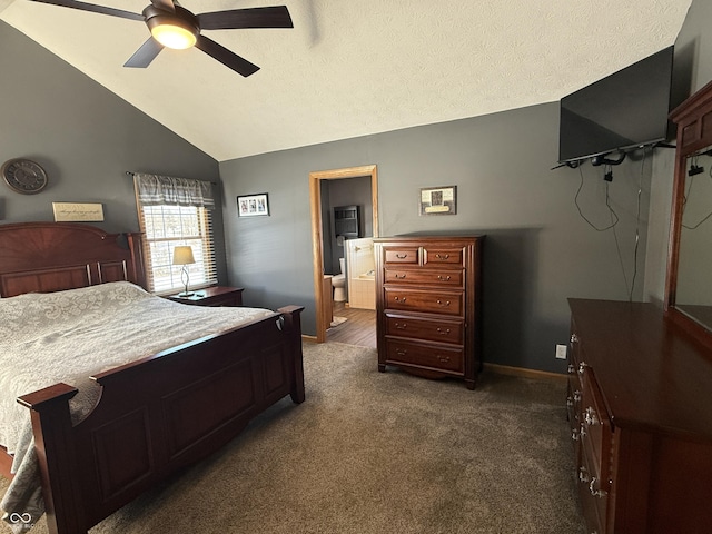 carpeted bedroom featuring ceiling fan, ensuite bathroom, vaulted ceiling, and a textured ceiling