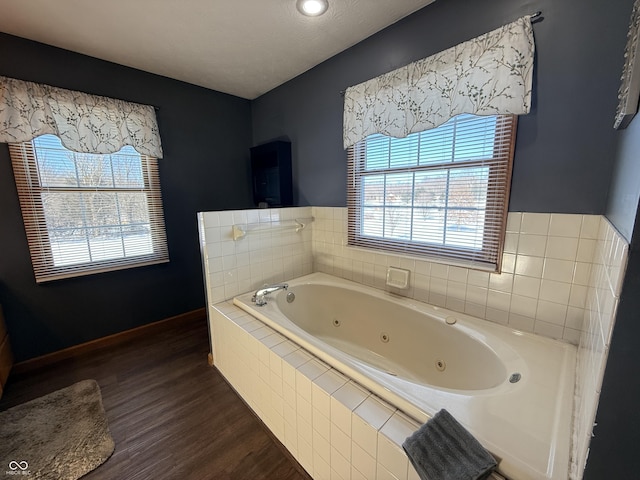 bathroom with hardwood / wood-style flooring and tiled bath