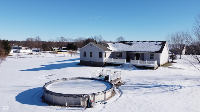 view of snow covered back of property