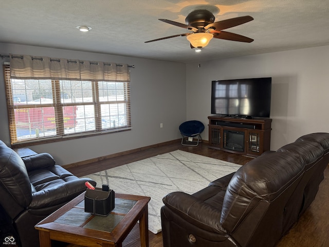 living room with ceiling fan, wood-type flooring, and a textured ceiling