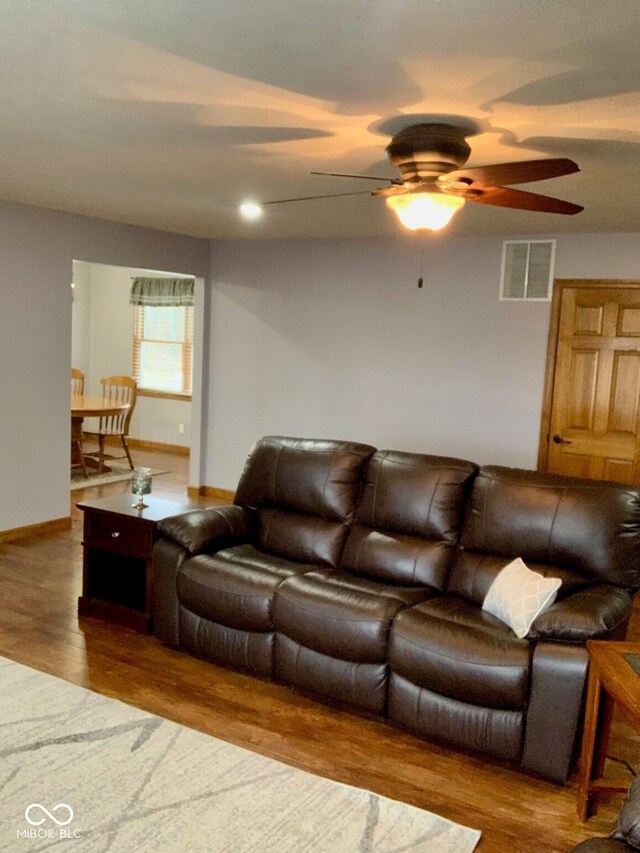 living room featuring hardwood / wood-style floors and ceiling fan