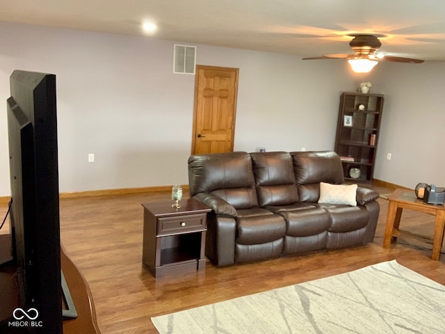 living room featuring light hardwood / wood-style flooring and ceiling fan