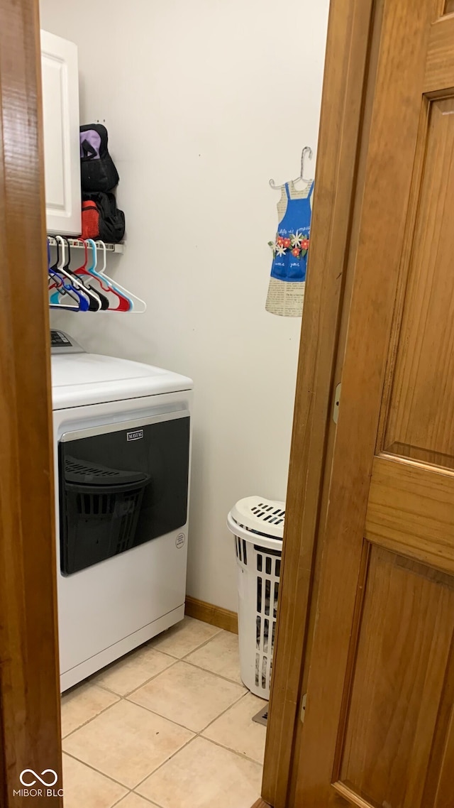 laundry area featuring cabinets, washer / dryer, and light tile patterned floors