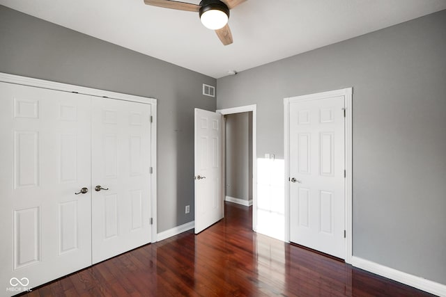 unfurnished bedroom featuring dark hardwood / wood-style floors, ceiling fan, and a closet