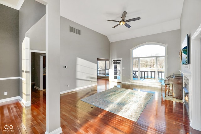 unfurnished living room with hardwood / wood-style flooring, high vaulted ceiling, and ceiling fan