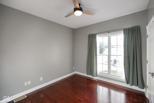 empty room with a healthy amount of sunlight, hardwood / wood-style floors, and ceiling fan