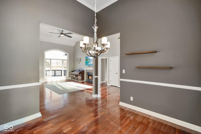 unfurnished dining area with hardwood / wood-style flooring, vaulted ceiling, and ceiling fan with notable chandelier