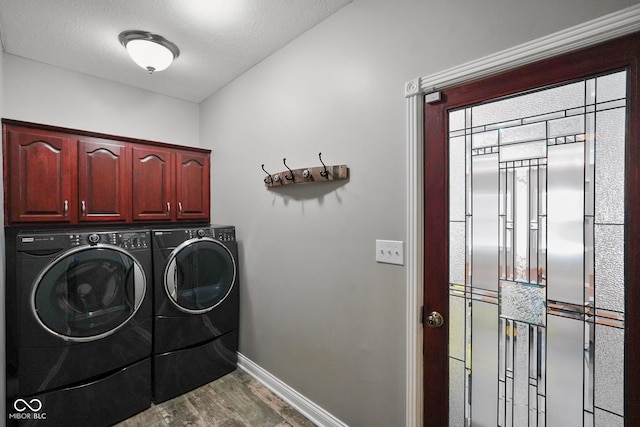 laundry room featuring washer and clothes dryer, cabinets, and wood-type flooring