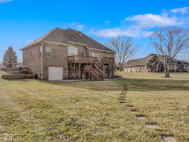 rear view of house featuring a garage, a deck, and a lawn