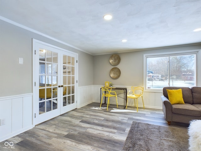 interior space featuring wood-type flooring, ornamental molding, and french doors