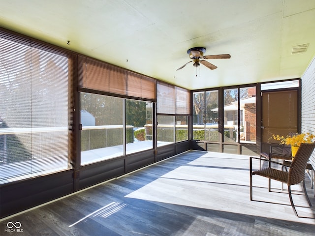 unfurnished sunroom featuring ceiling fan