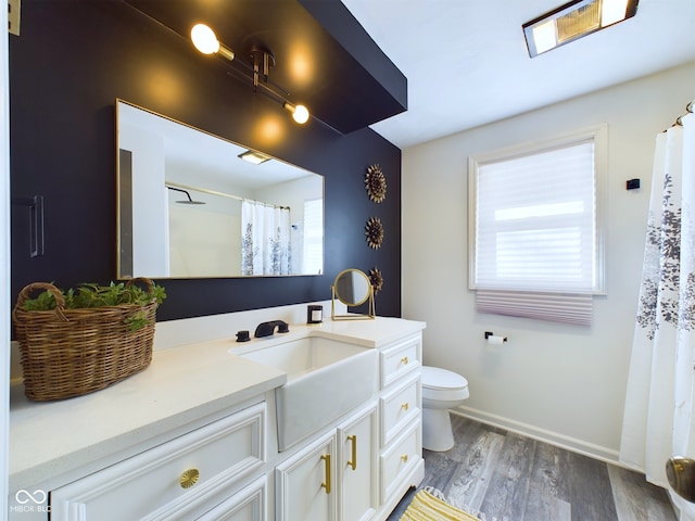 bathroom featuring a shower with curtain, hardwood / wood-style floors, toilet, and vanity