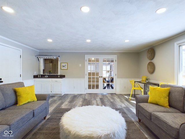 living room with sink, hardwood / wood-style floors, crown molding, and french doors