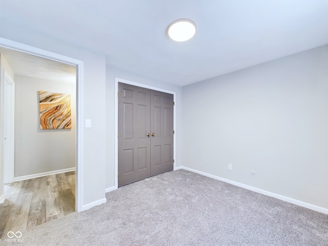 unfurnished bedroom with a closet and light colored carpet