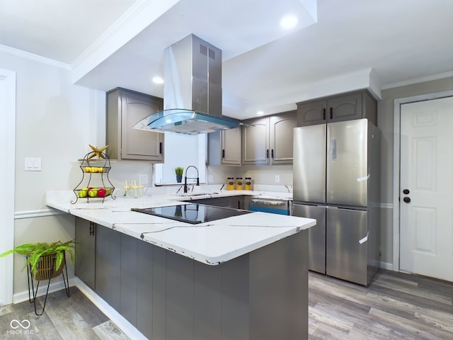 kitchen featuring kitchen peninsula, black electric stovetop, island exhaust hood, and stainless steel refrigerator