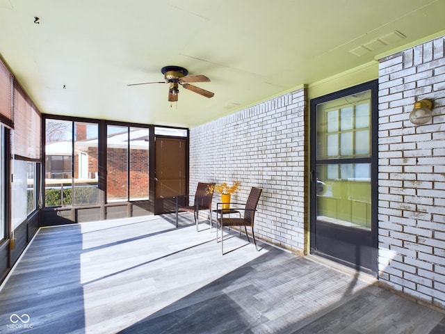 unfurnished sunroom with ceiling fan